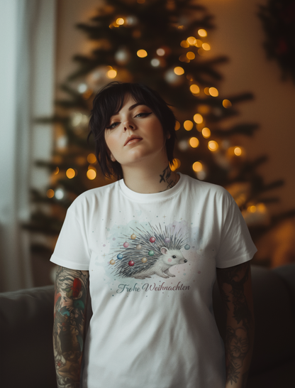 Woman standing by Christmas tree wearing white t-shirt with hedgehog print
